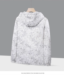 Détail de la veste à capuche avec imprimé feuilles tropicales et poignets élastiques
