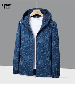 Détail du coupe-vent bleu avec motif de feuilles tropicales, capuche et poches zippées