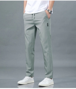 Détail du pantalon en soie glacée vert clair avec cordon de serrage et étiquette tissée
