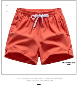 Detailed view of watermelon red athletic shorts with elastic drawstring waist and side slits