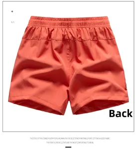 Back view of orange-red loose sports shorts with elastic waistband and cotton texture