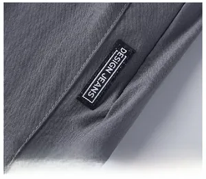 Détail du tissu en soie glacée grise avec coutures soignées et étiquette design jeans