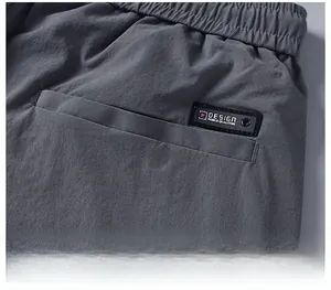Détail du pantalon gris foncé avec taille élastique et poche arrière à étiquette