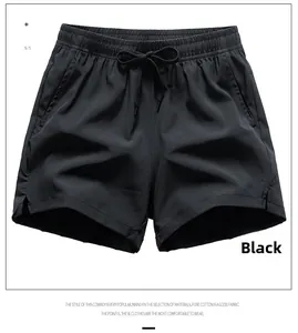 Detail of black quick-dry sports shorts showing elastic drawstring waist and side slit design