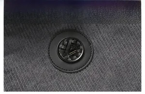 Close-up of metal crown badge on grey corduroy jacket with warm fleece lining