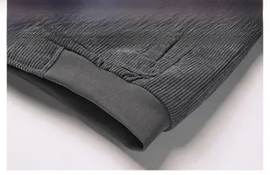 Detail of ribbed hem on dark gray corduroy jacket showing texture and elastic stitching