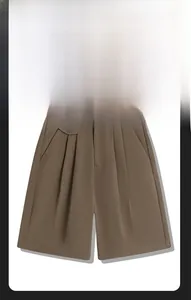 Detailed close-up of brown casual shorts with elastic waist and tailored button pocket