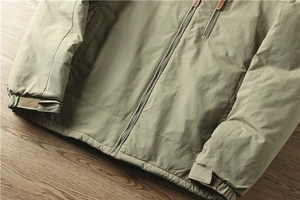 Detail van outdoorjas met winddichte stof, ritszak en verstelbare klittenbandmanchetten