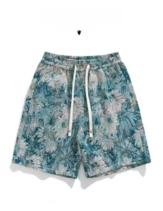 Detailed close-up of floral jacquard fabric on turquoise men's casual drawstring shorts