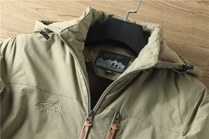 Detailweergave van de olijfgroene jas met warme fleecevoering en outdoorborduurwerk