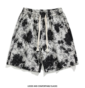 Detail of loose and comfortable men's shorts with a black and white leaf print and drawstring