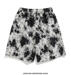 Detailed fabric texture of loose cotton shorts with black and white floral ink print