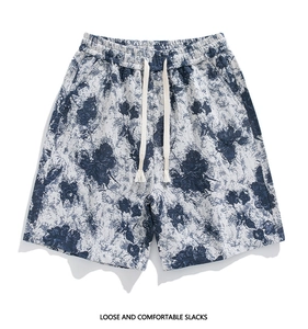 Detail of grey-white cotton shorts with navy blue vintage rose floral pattern and drawstring