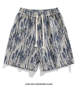 Detail of loose fit shorts featuring blue and white texture with tassel drawstrings