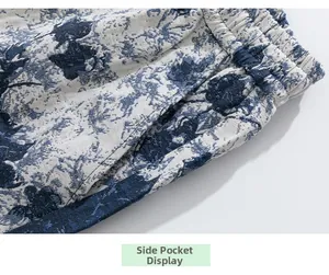 Detail view of side pocket and blue floral print on elastic waist beach shorts