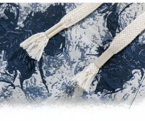 Close-up of blue and white jacquard fabric with woven drawstring and engraved aglet