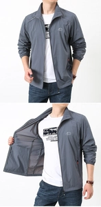 Detail view of a gray outdoor sun protection jacket with mountain logo and stand collar