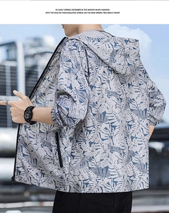 Detail of hooded sun protection jacket with blue-grey palm leaf print and drawstring