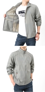 Detail of light gray sun protection jacket showing ripstop texture and zipper pocket
