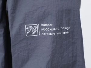Dettaglio della giacca outdoor che mostra il tessuto tecnico e la stampa Adventure Spirit
