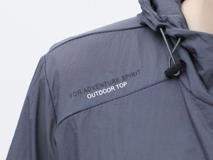 Dettaglio della giacca outdoor con stampa 'FOR ADVENTURE SPIRIT' e tessuto ripstop