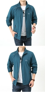 Detail view of the standing collar and mountain logo on a teal outdoor sun jacket