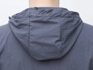 Vista posteriore dettagliata di una giacca outdoor con cappuccio in tessuto grigio scuro