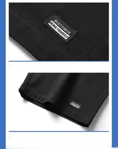 Detail of woven label on black cotton shorts showing quality stitching and hem