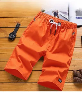 Flat lay detail of orange cotton shorts featuring elastic waist and white drawstrings