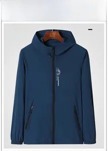 Detail of denim blue sun protection jacket with hood, zip pockets and mountain chest logo
