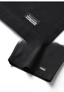 Detail of black cotton shorts featuring woven label with text and premium hem stitching