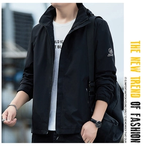 Détail de la veste noire coupe-vent avec capuche et logo imprimé sur la manche
