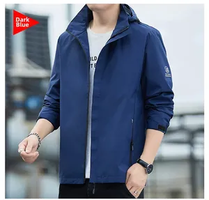 Détail de la veste imperméable bleu foncé montrant les poignets velcro et poches zippées