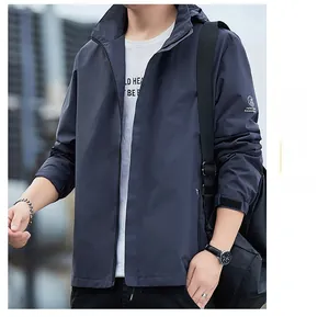 Détail de la veste grise coupe-vent montrant le logo sur la manche et le tissu outdoor