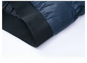 Detail of navy blue quilted puffer jacket with black elastic ribbed hem and windproof fabric