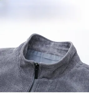 Detail view of grey corduroy jacket collar with zipper and windproof material texture