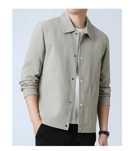 Detail of light gray men's jacket showing waffle texture fabric and silver metal buttons