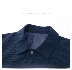 Detail of navy blue men's jacket with waffle texture fabric and premium lapel snap button