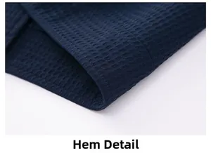Macro detail of the hem stitching on a navy blue waffle knit jacket for men