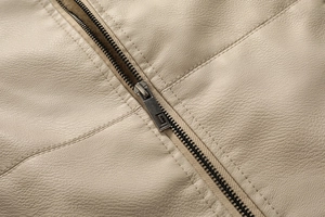 Detailed close-up of a high-quality metal zipper and textured lychee grain leather jacket