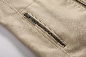 Macro shot of cream biker jacket showing litchi grain leather and metal zipper pocket