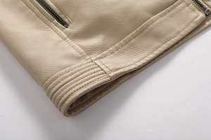 Detailed macro view of beige PU leather texture with metal zipper and ribbed hem