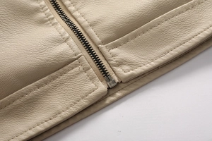 Detail of beige leather jacket showing zipper base and precise double stitching