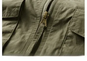 Détail du zip en bronze rétro et des coutures renforcées sur le gilet vert armée