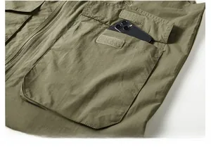 Détail du gilet outdoor vert armée montrant une grande poche à rabat avec velcro