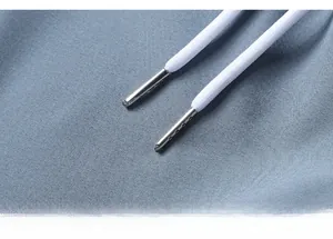 Detail of blue-grey sports shorts with white drawstring and silver metal tips