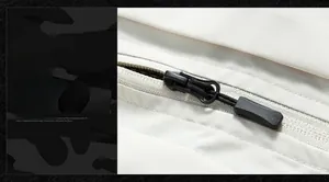 Détail de la fermeture éclair noire fluide sur le tissu blanc texturé du gilet