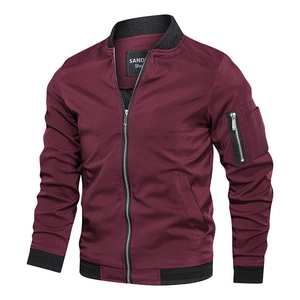 Detail of burgundy bomber jacket showing silver zipper and tactical utility pocket on sleeve