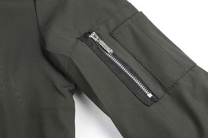 Detailed view of an olive green bomber jacket sleeve featuring a utility zipper pocket