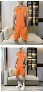 Detail of orange men's quick-dry sports set with vest and shorts showing breathable fabric